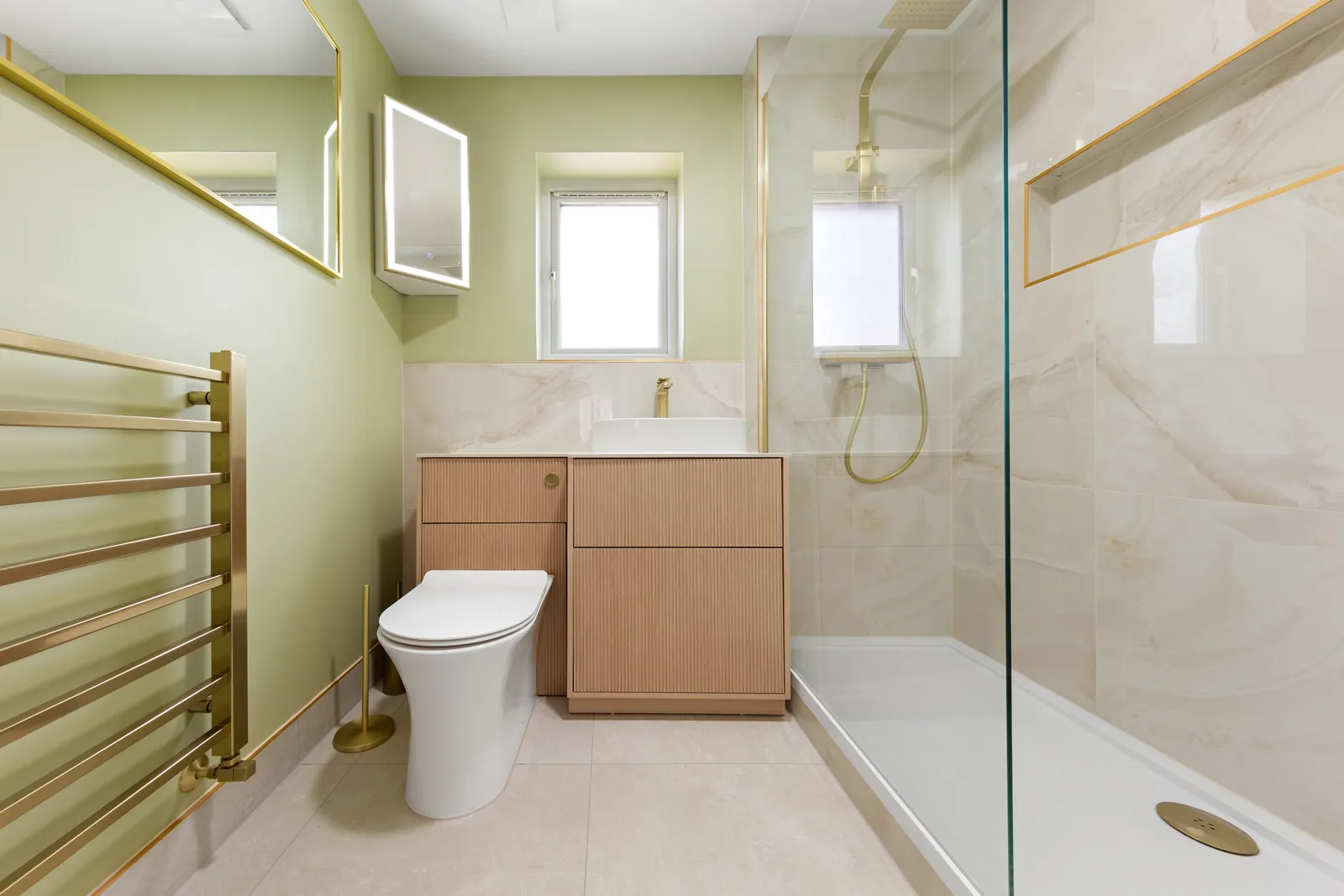 Sleek bathroom refurbishment with walk-in shower, fluted wood vanity and brass fittings completed in Rotherhithe, SE16 London by Buildaway